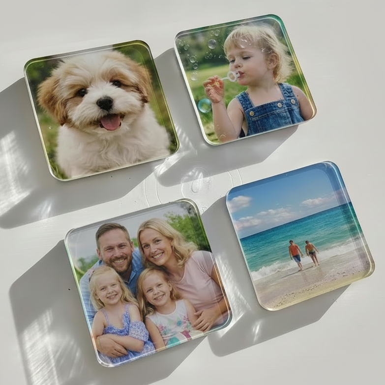 Four square photo magnets with printed images of a dog, a child blowing bubbles, a family, and a beach.